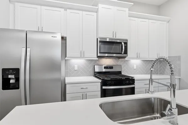 a kitchen with a refrigerator and a stove top oven