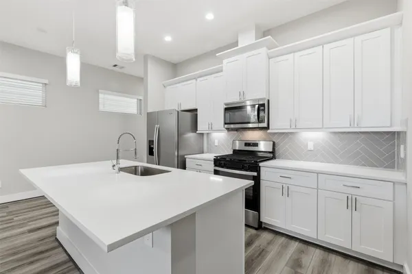 a kitchen with a sink and steel appliances