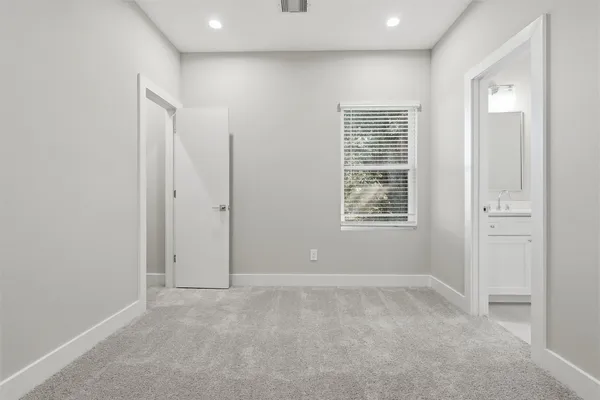 an empty room with closet and a chandelier fan