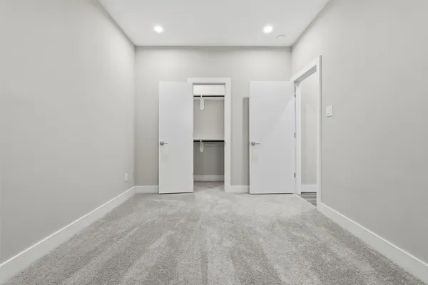 an empty room with closet and a chandelier fan