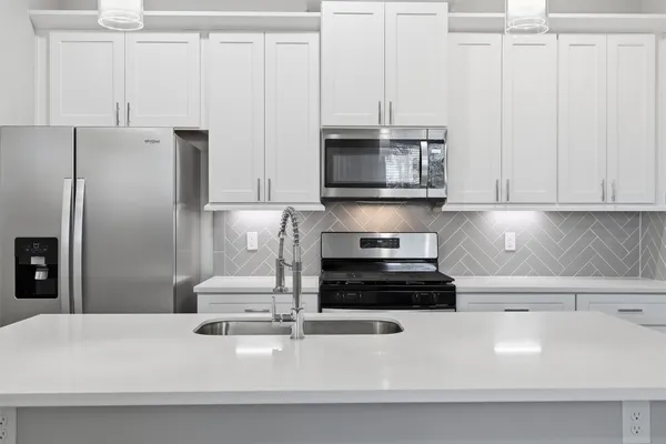 a kitchen with appliances a sink and cabinets