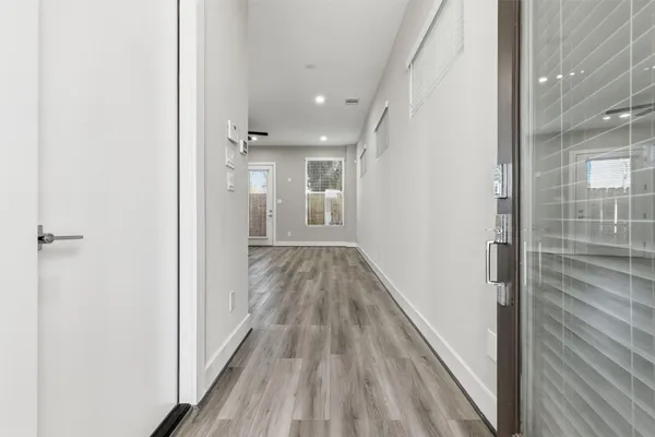 a view of an empty room with a window and wooden floor