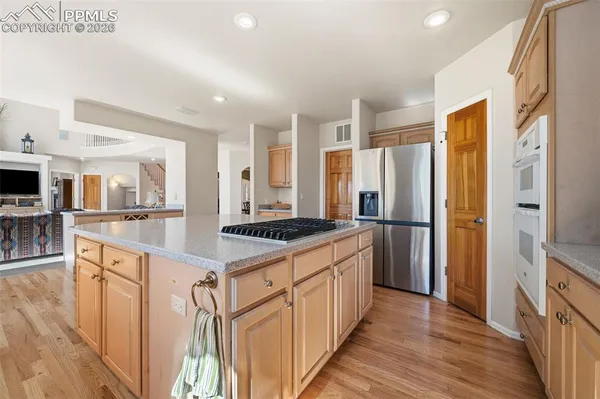 a kitchen with stainless steel appliances granite countertop a refrigerator a stove and a sink