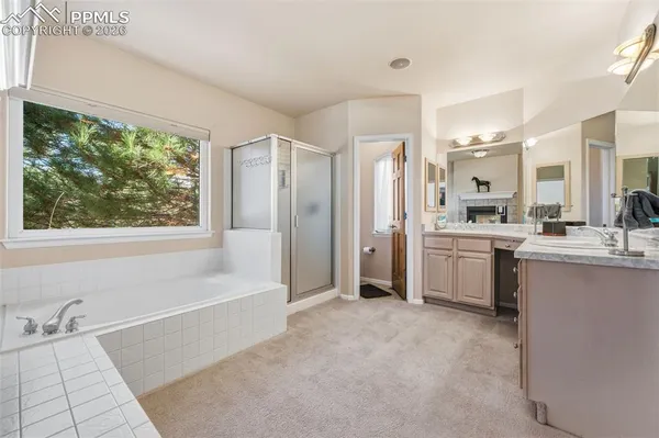a bathroom with a tub a sink a mirror and a bathtub