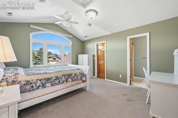 a bedroom with a large bed and a chandelier