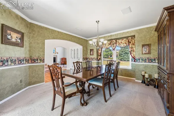 a dining room with furniture a chandelier and window