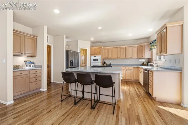 a kitchen with a sink cabinets and wooden floor