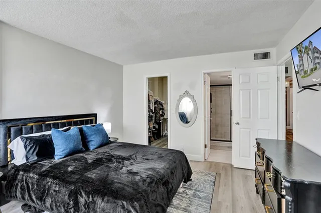 a bed sitting in a bedroom next to a window with wooden floor