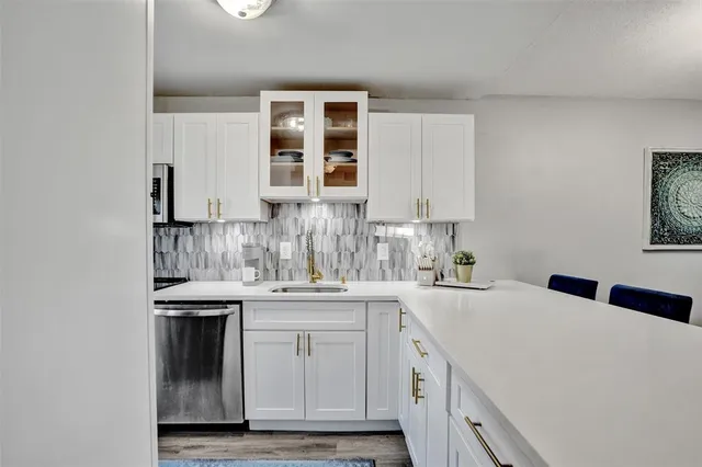 a kitchen with stainless steel appliances granite countertop a sink and cabinets