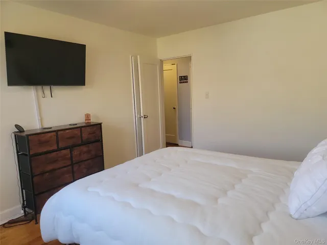 a bedroom with a bed and a flat screen tv