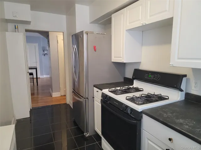 a kitchen with granite countertop a refrigerator and a stove