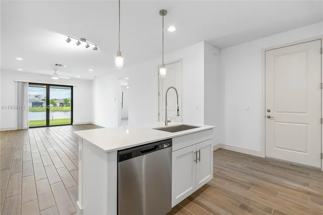 a kitchen with a sink a counter space and wooden floor