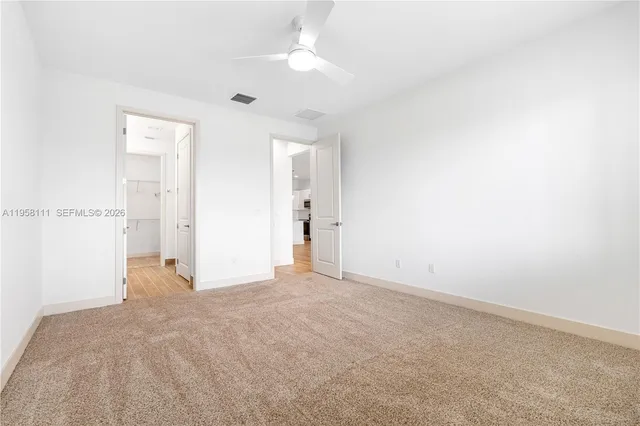 an empty room with closet and a chandelier fan