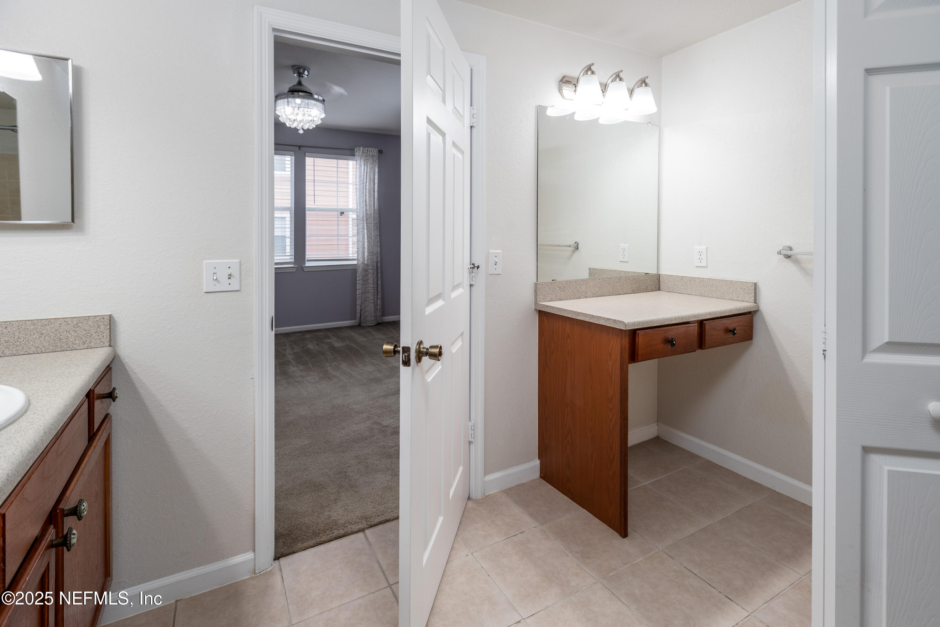 8550 Touchton Road, Unit 428 Jacksonville, FL 32216 - Photo 13 of 26 a view of a bathroom with a sink and mirror
