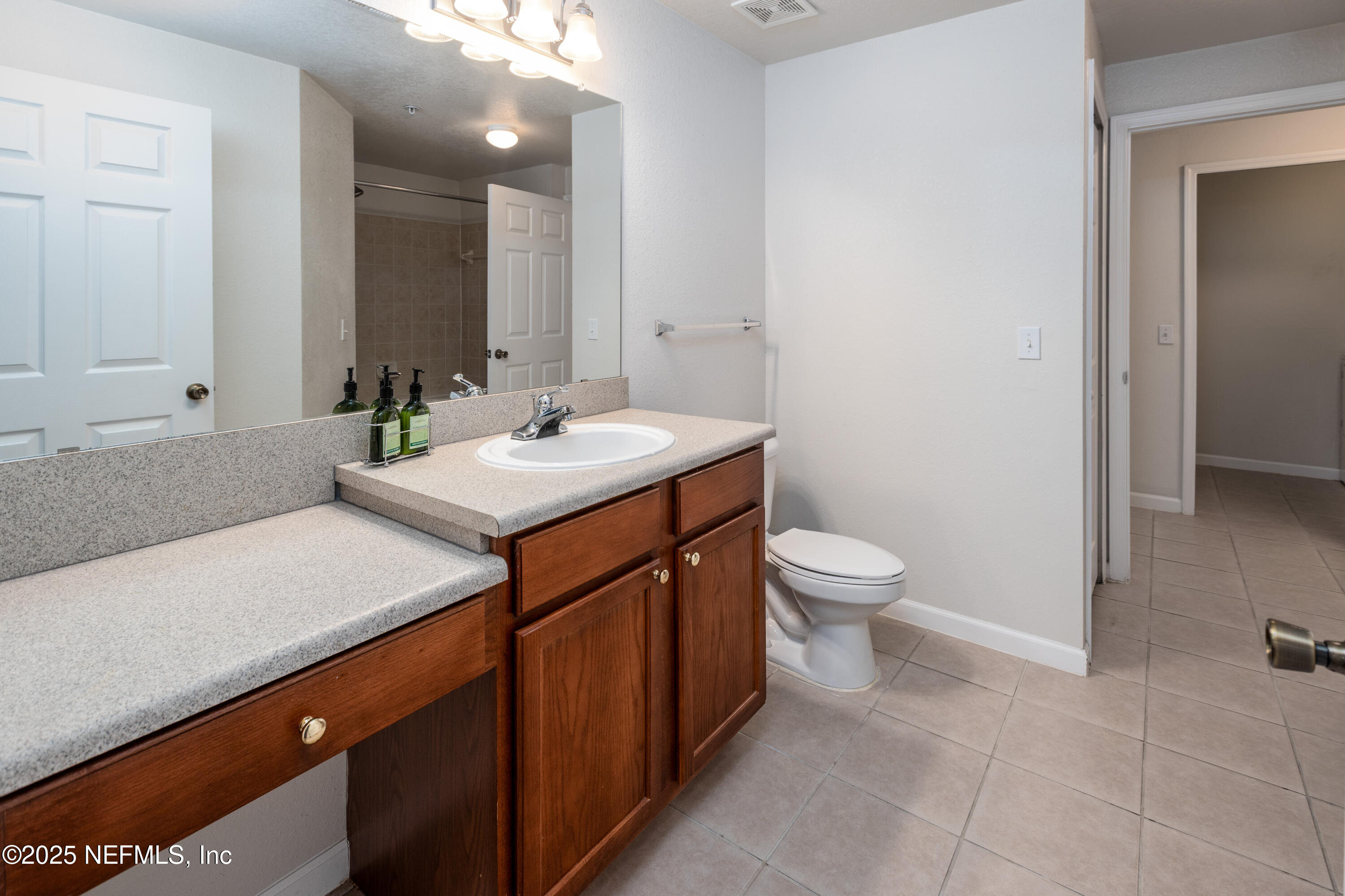 8550 Touchton Road, Unit 428 Jacksonville, FL 32216 - Photo 9 of 26 a bathroom with a sink a toilet and a mirror