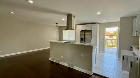 an open kitchen with wooden floor and window