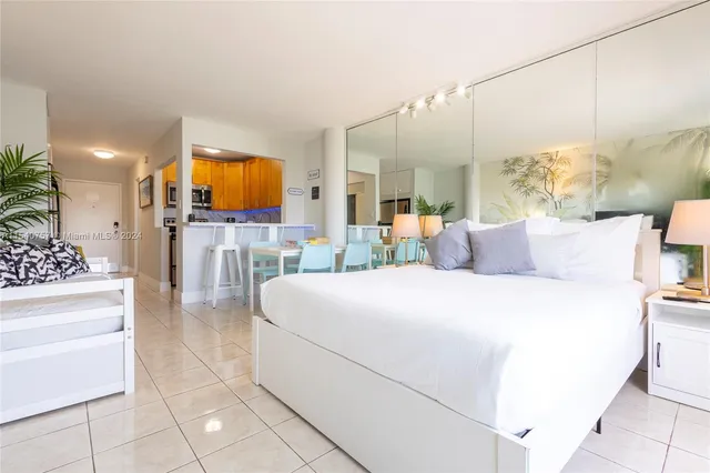 a bedroom with a bed a mirror and lamp