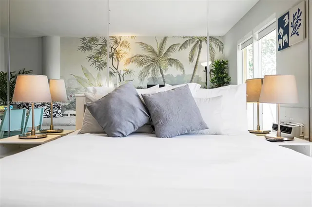 a spacious bedroom with a bed and a lamp