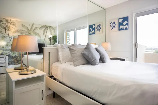 a spacious bedroom with a bed and a lamp