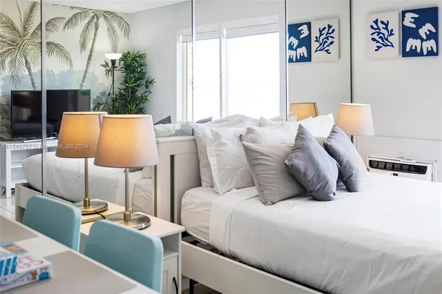 a bedroom with a bed a lamp and a potted plant