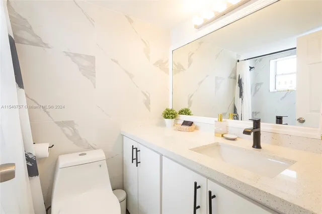 a bathroom with a sink a toilet and a mirror