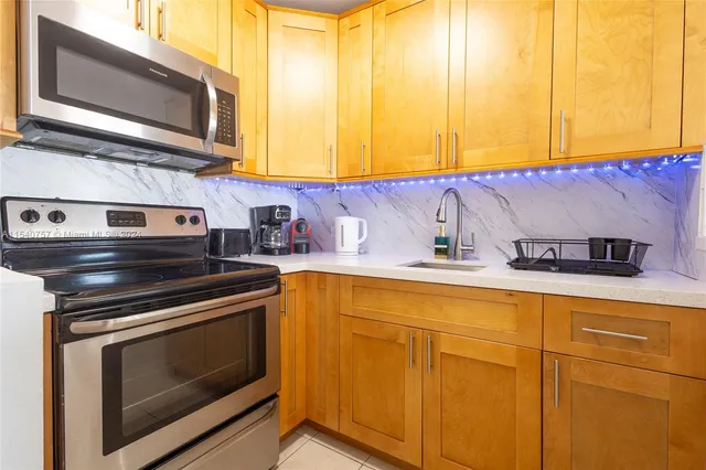 a kitchen with stainless steel appliances granite countertop cabinets and a stove top oven