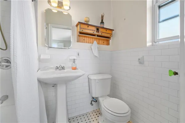 a bathroom with a sink a toilet and mirror