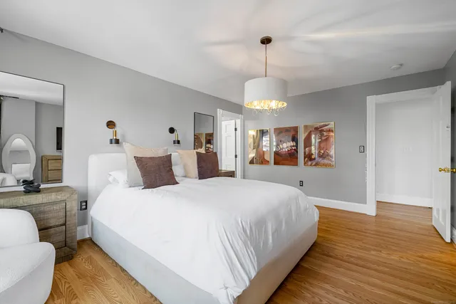 a spacious bedroom with a bed and a chandelier