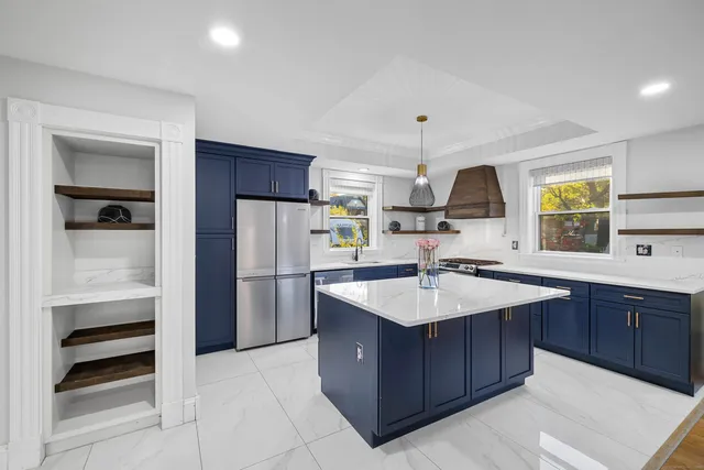 a kitchen with a sink a counter top space stainless steel appliances and cabinets