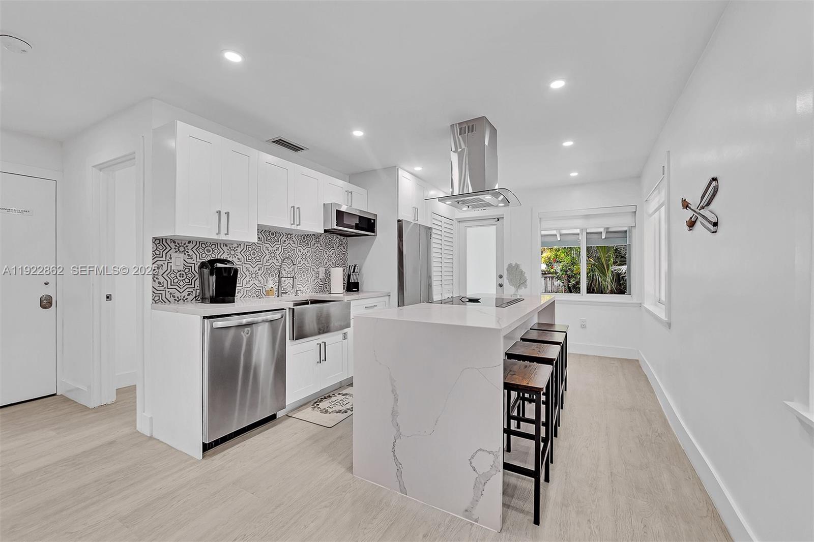 1960 Riverside Drive Fort Lauderdale, FL 33312 - Photo 27 of 89 a kitchen with white cabinets and stainless steel appliances