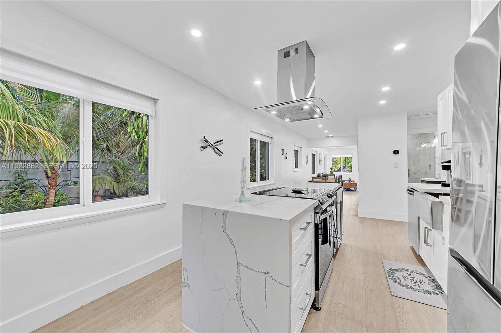 1960 Riverside Drive Fort Lauderdale, FL 33312 - Photo 38 of 89 a kitchen with stainless steel appliances kitchen island granite countertop a refrigerator oven a sink dishwasher and white cabinets next to a window