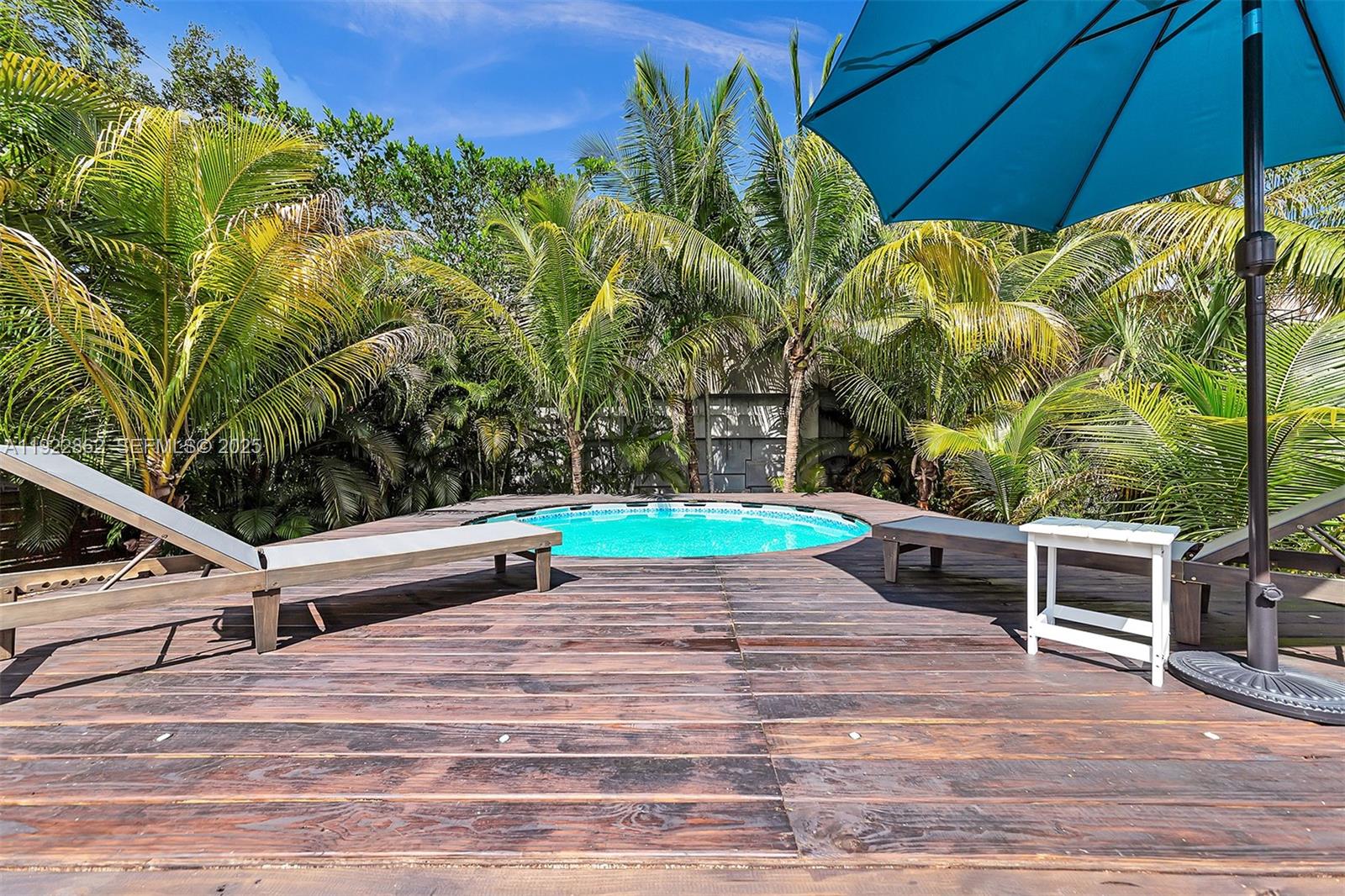 1960 Riverside Drive Fort Lauderdale, FL 33312 - Photo 76 of 89 a backyard with a table and chairs under an umbrella