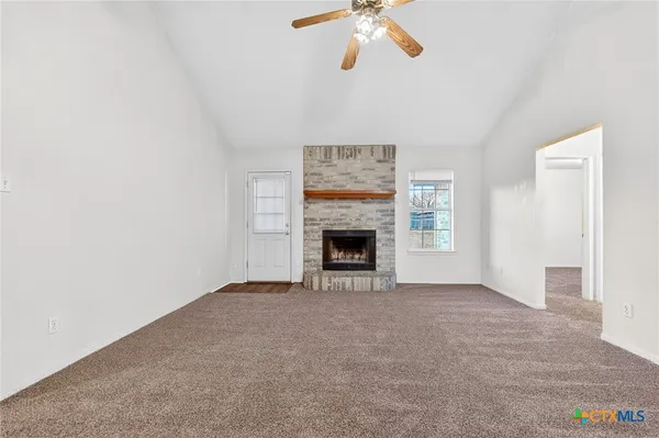 an empty room with a fireplace and fan