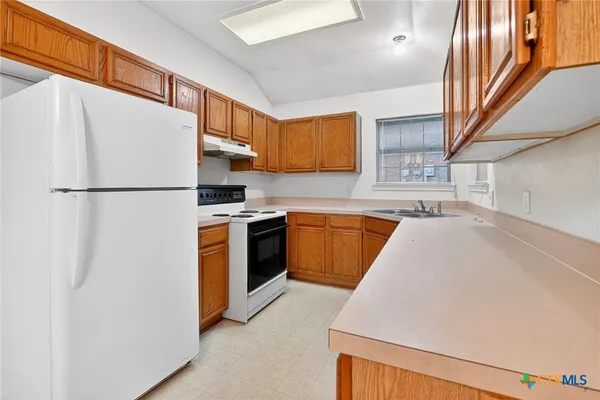 a kitchen with stainless steel appliances a refrigerator sink and cabinets