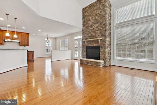 a view of a living room with wooden floor and a fireplace