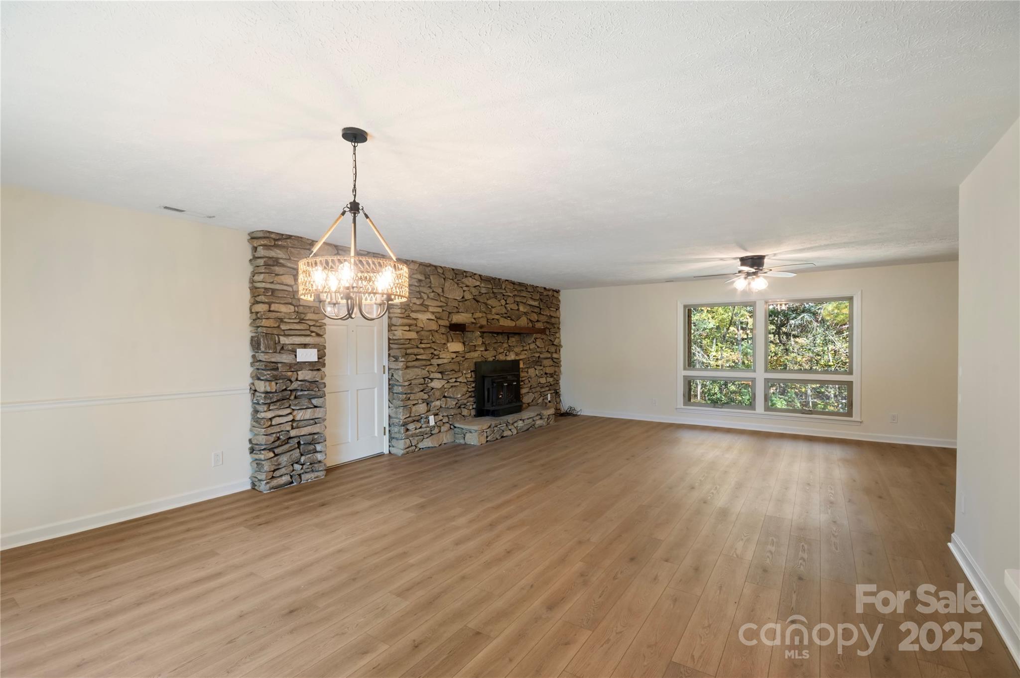 90 Joe Jenkins Road Fairview, NC 28730 - Photo 11 of 46 an empty room with windows and fireplace