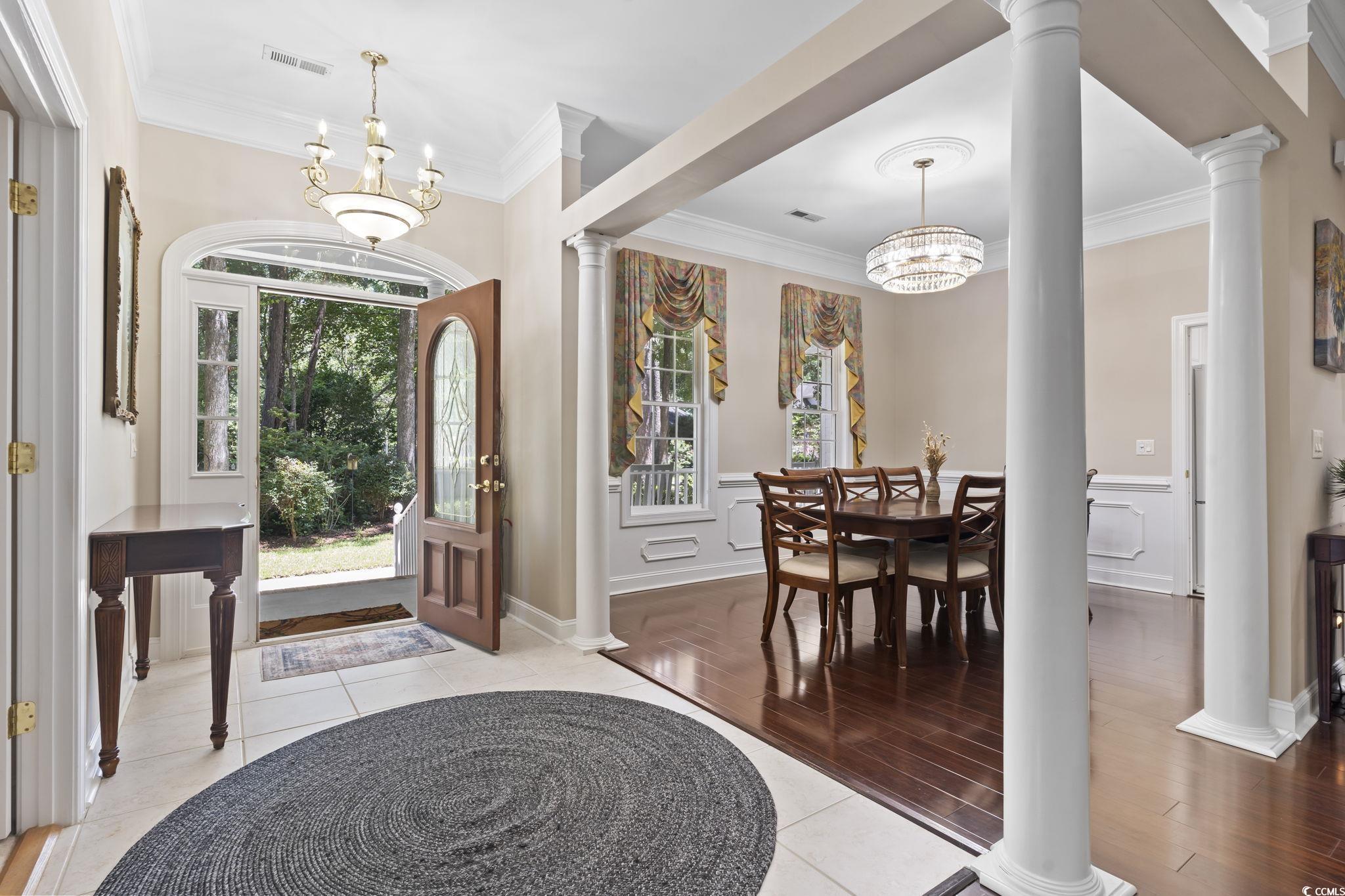 4495 Trotters Court Murrells Inlet, SC 29576 - Photo 16 of 29 Foyer with a chandelier, crown molding, decorative columns, wood finished floors, and a wainscoted wall