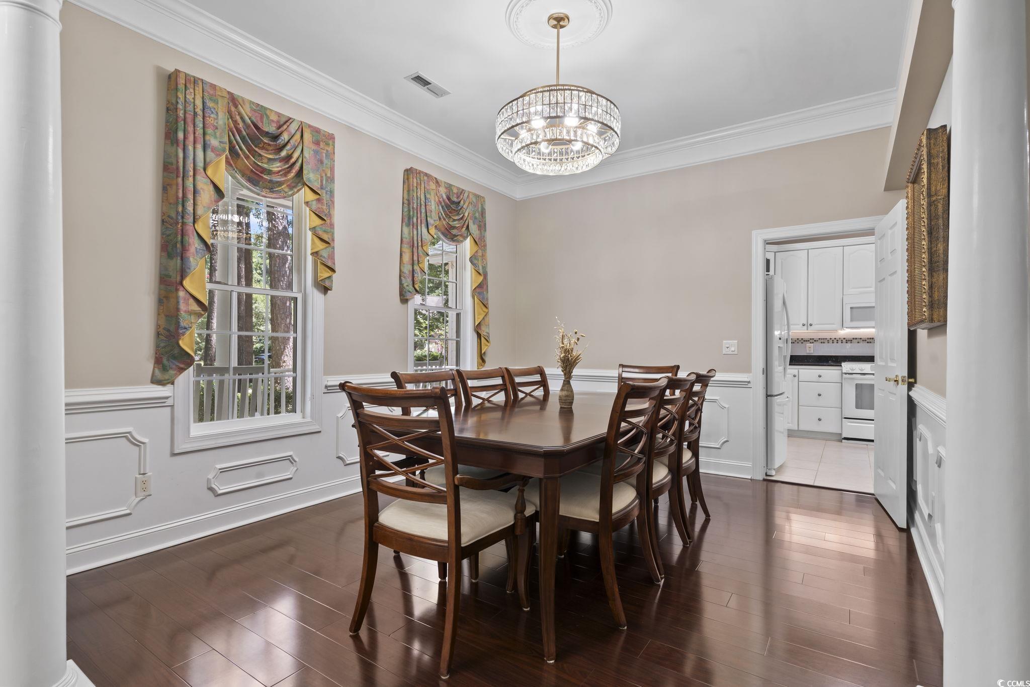 4495 Trotters Court Murrells Inlet, SC 29576 - Photo 17 of 29 Dining space with a chandelier, crown molding, dark wood finished floors, and wainscoting