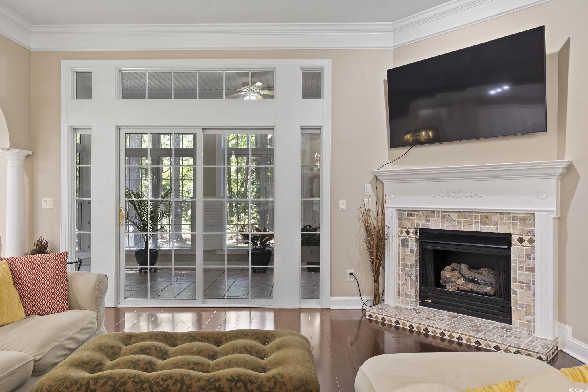 4495 Trotters Court Murrells Inlet, SC 29576 - Photo 19 of 29 Living area with wood finished floors, a fireplace, a ceiling fan, and crown molding