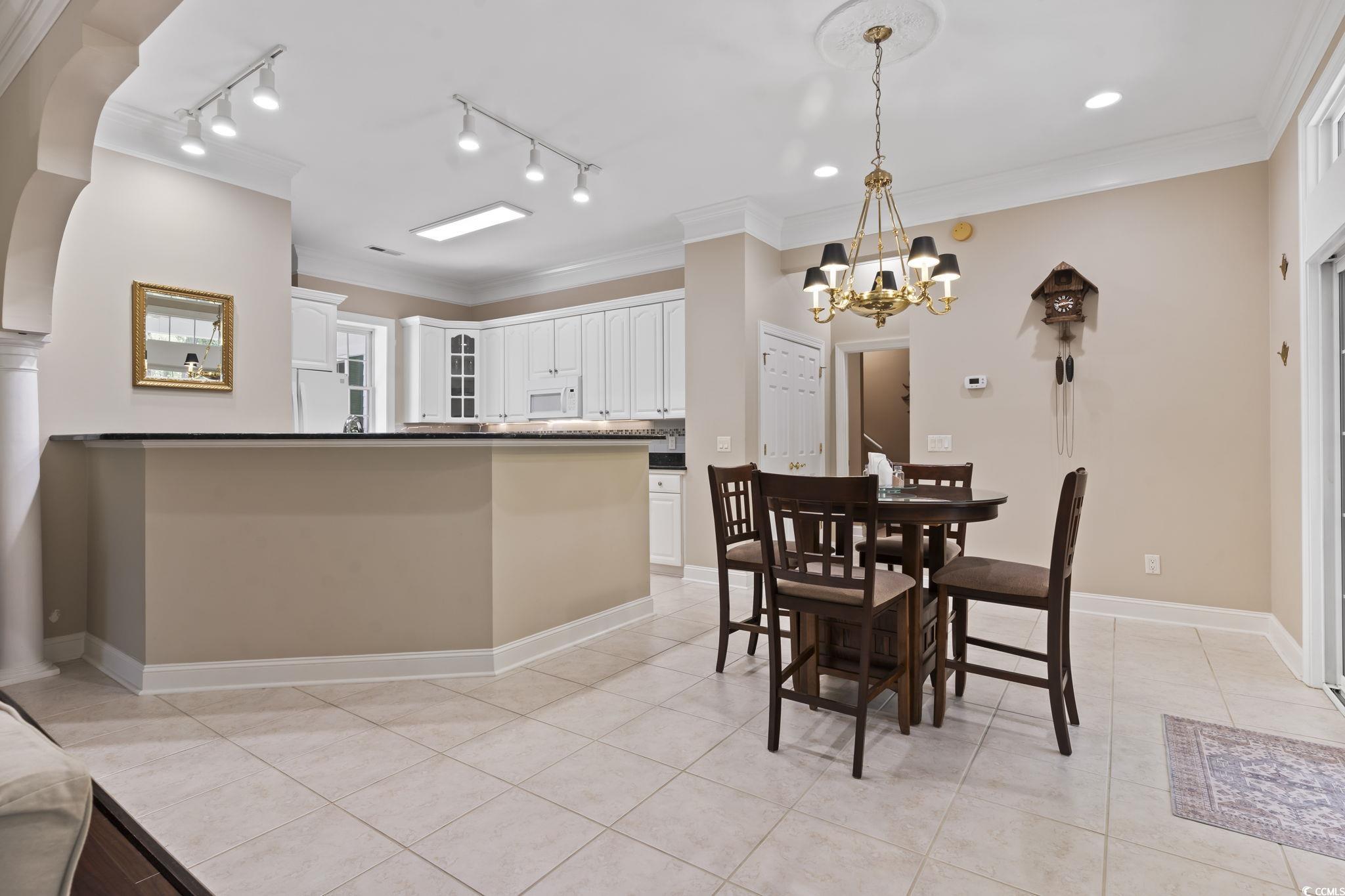 4495 Trotters Court Murrells Inlet, SC 29576 - Photo 21 of 29 Dining room with light tile patterned floors, a chandelier, crown molding, and rail lighting
