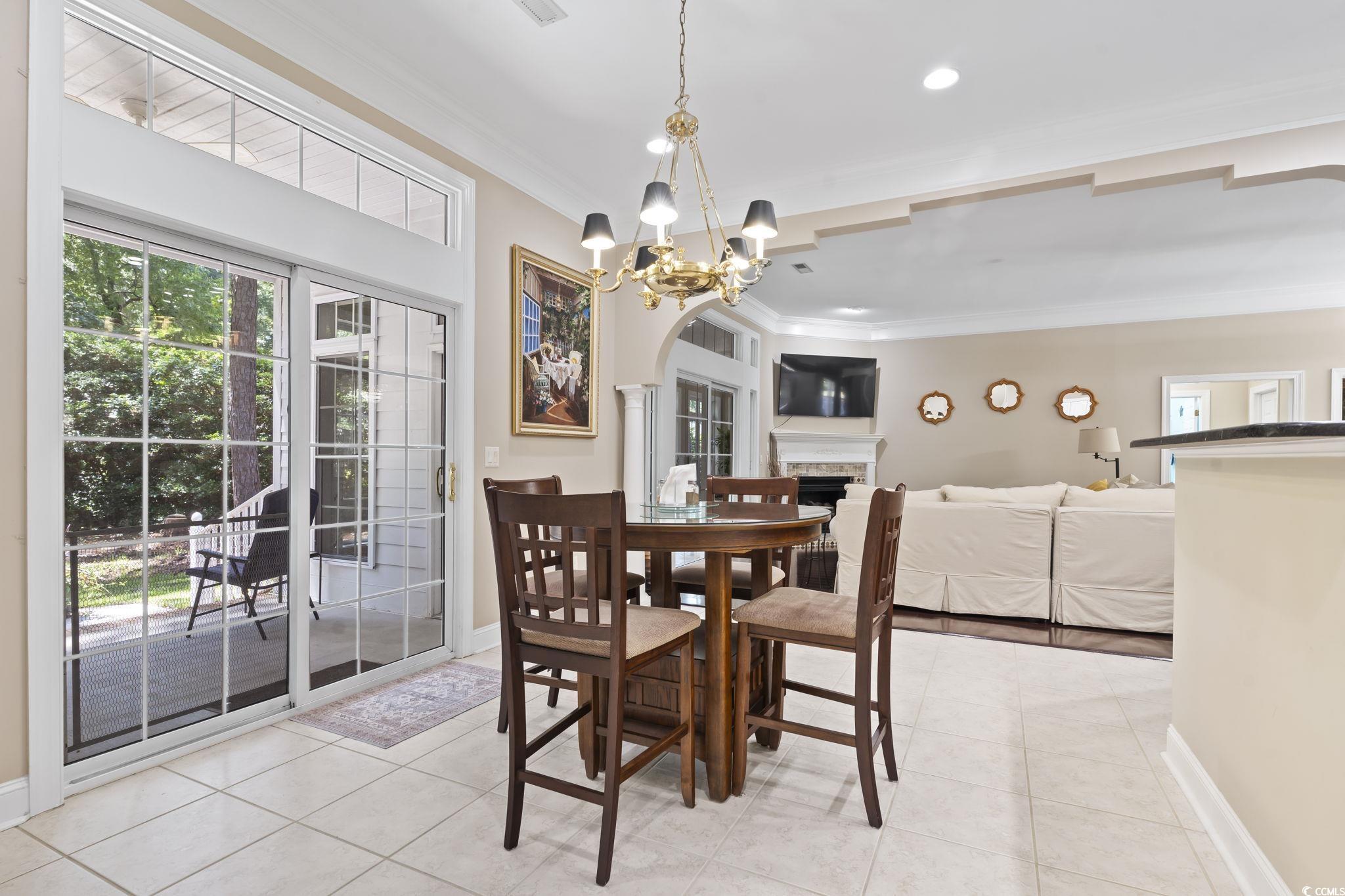 4495 Trotters Court Murrells Inlet, SC 29576 - Photo 24 of 29 Dining area featuring crown molding, a chandelier, light tile patterned floors, a fireplace, and recessed lighting