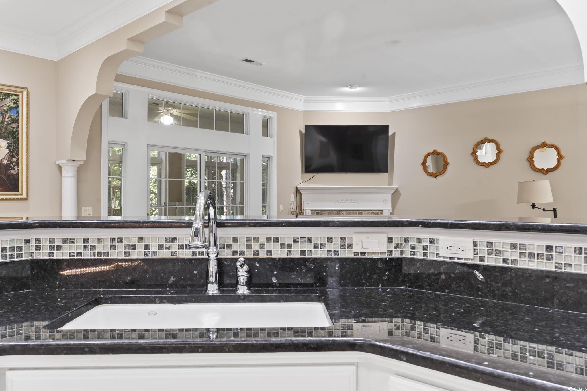 4495 Trotters Court Murrells Inlet, SC 29576 - Photo 27 of 29 Detailed view of ornamental molding, arched walkways, decorative backsplash, dark countertops, and a ceiling fan