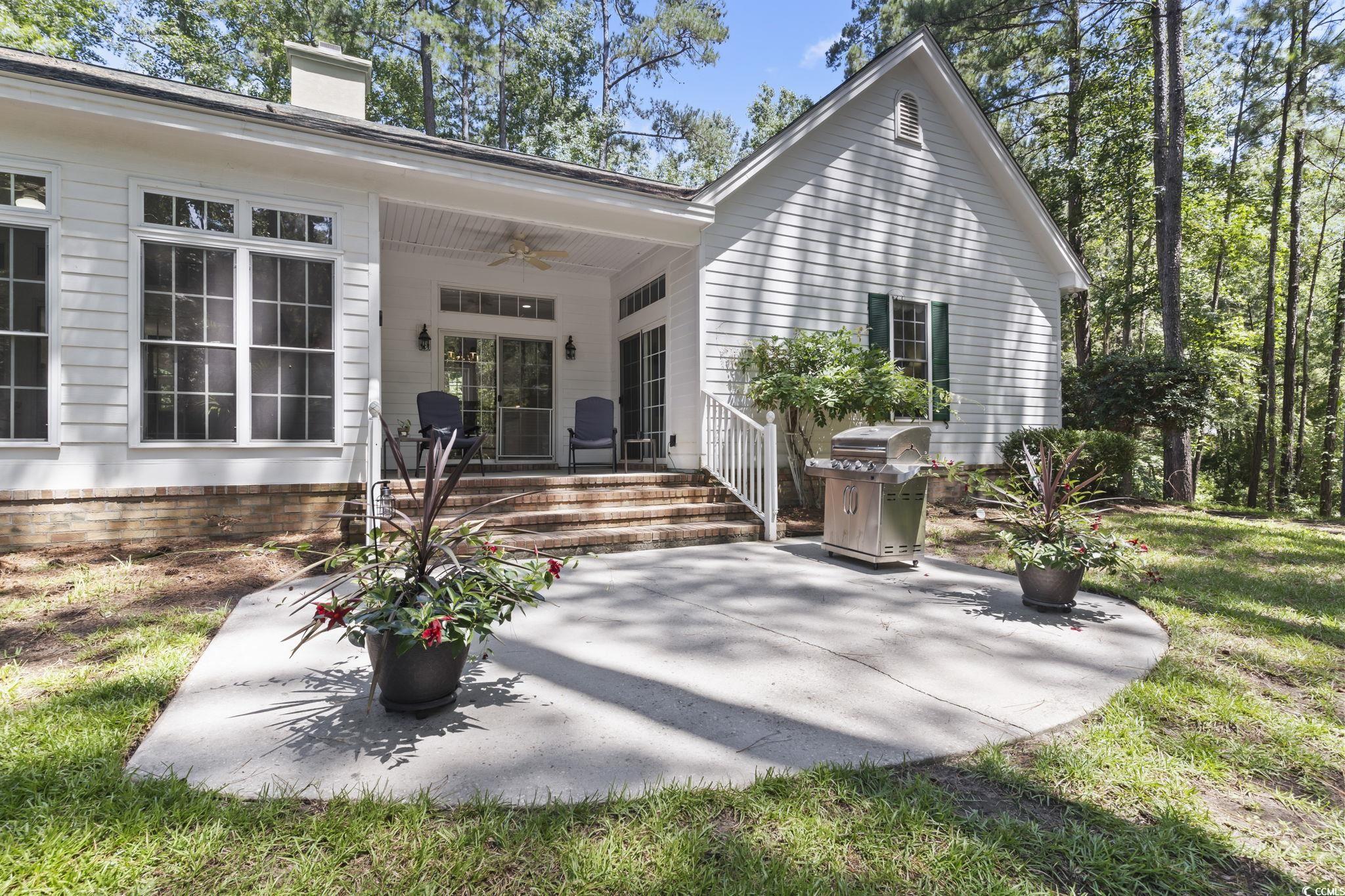 4495 Trotters Court Murrells Inlet, SC 29576 - Photo 29 of 29 Rear view of house featuring ceiling fan, a patio area, a chimney, and a lawn