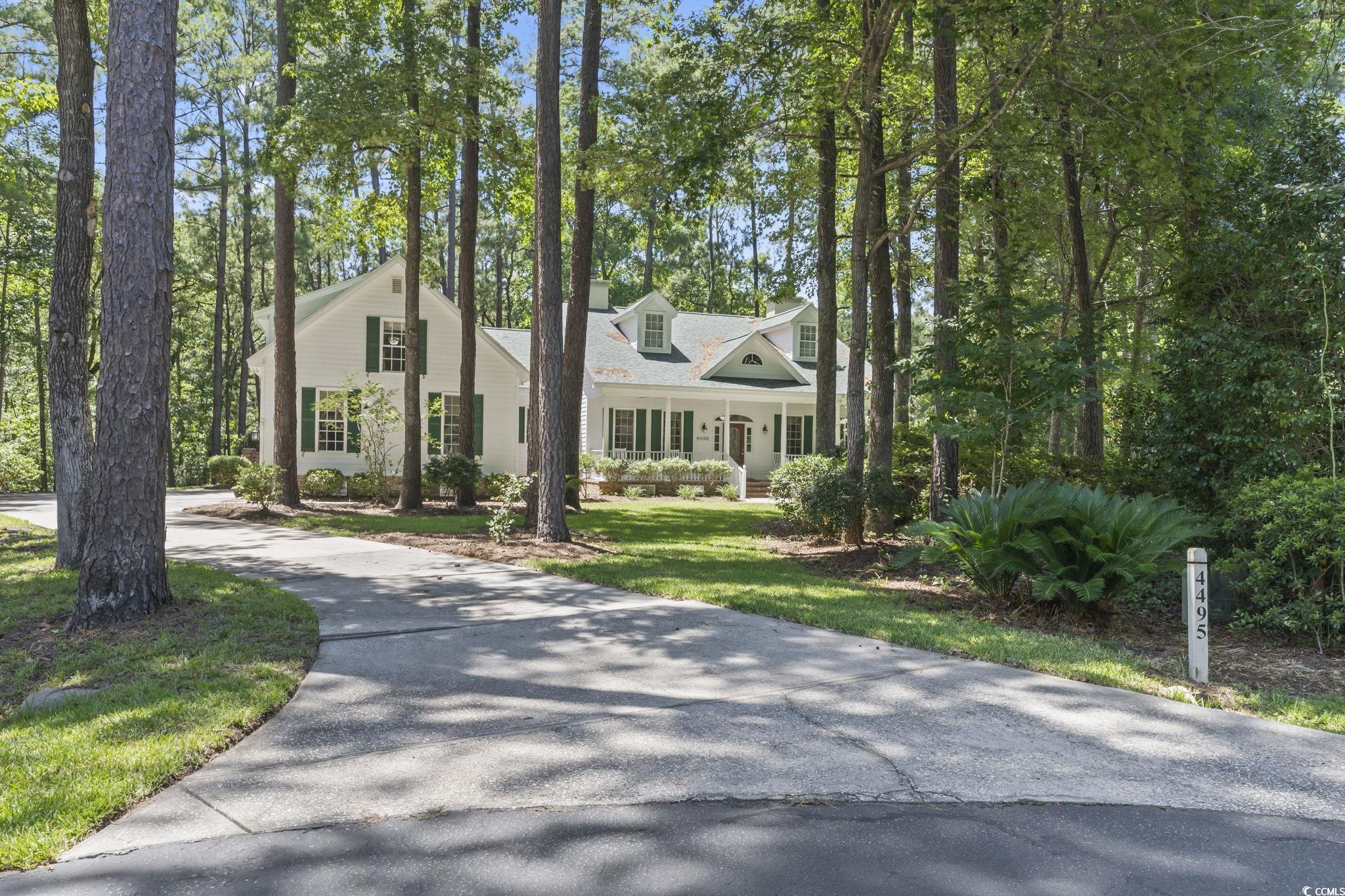 Cape cod-style house with driveway and a porch