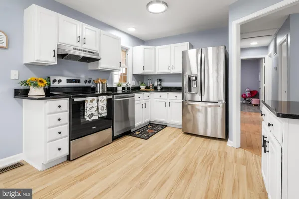a kitchen with stainless steel appliances granite countertop a refrigerator sink and stove