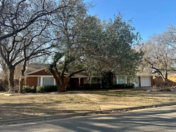 a front view of house with yard and trees
