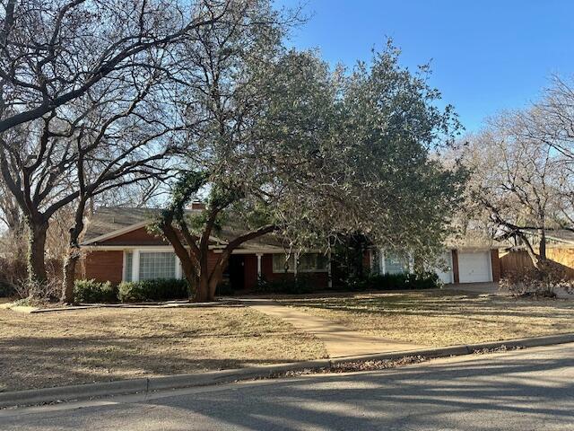 a front view of house with yard and trees