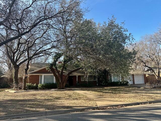 4503 14th Street Lubbock, TX 79416 - Photo 2 of 17 a front view of a house with a yard and trees