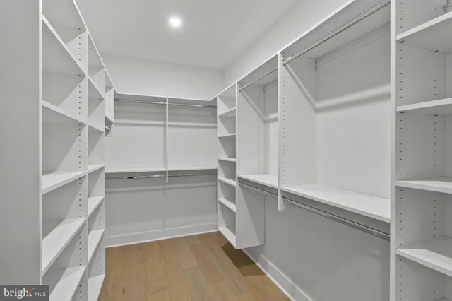 a view of walk in closet with empty racks