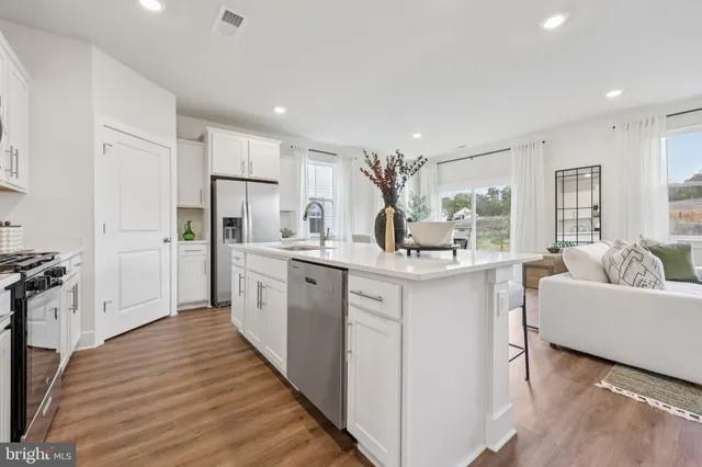 a kitchen with white cabinets and sink